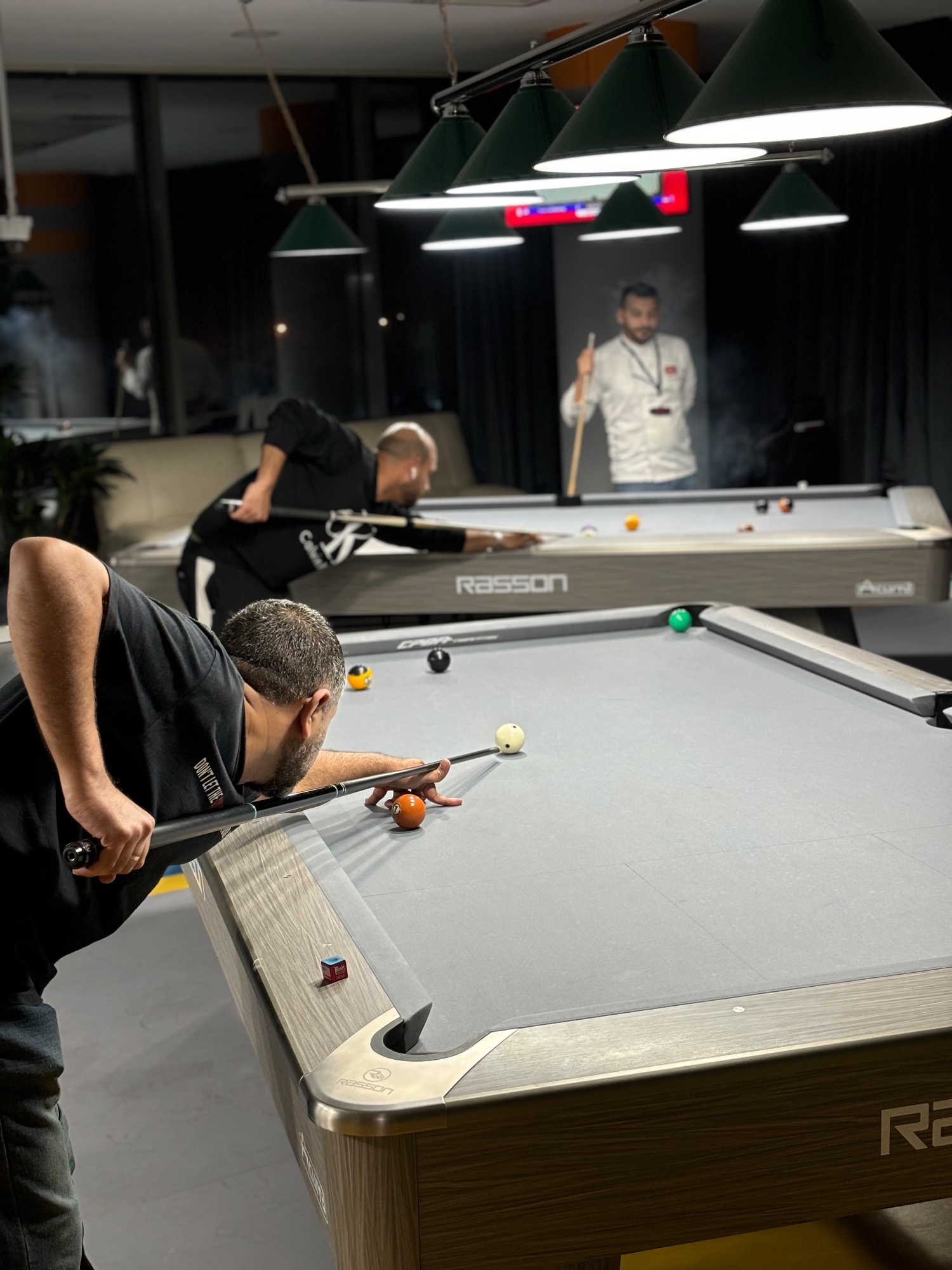 Racked balls on a pool table, bar in the background
